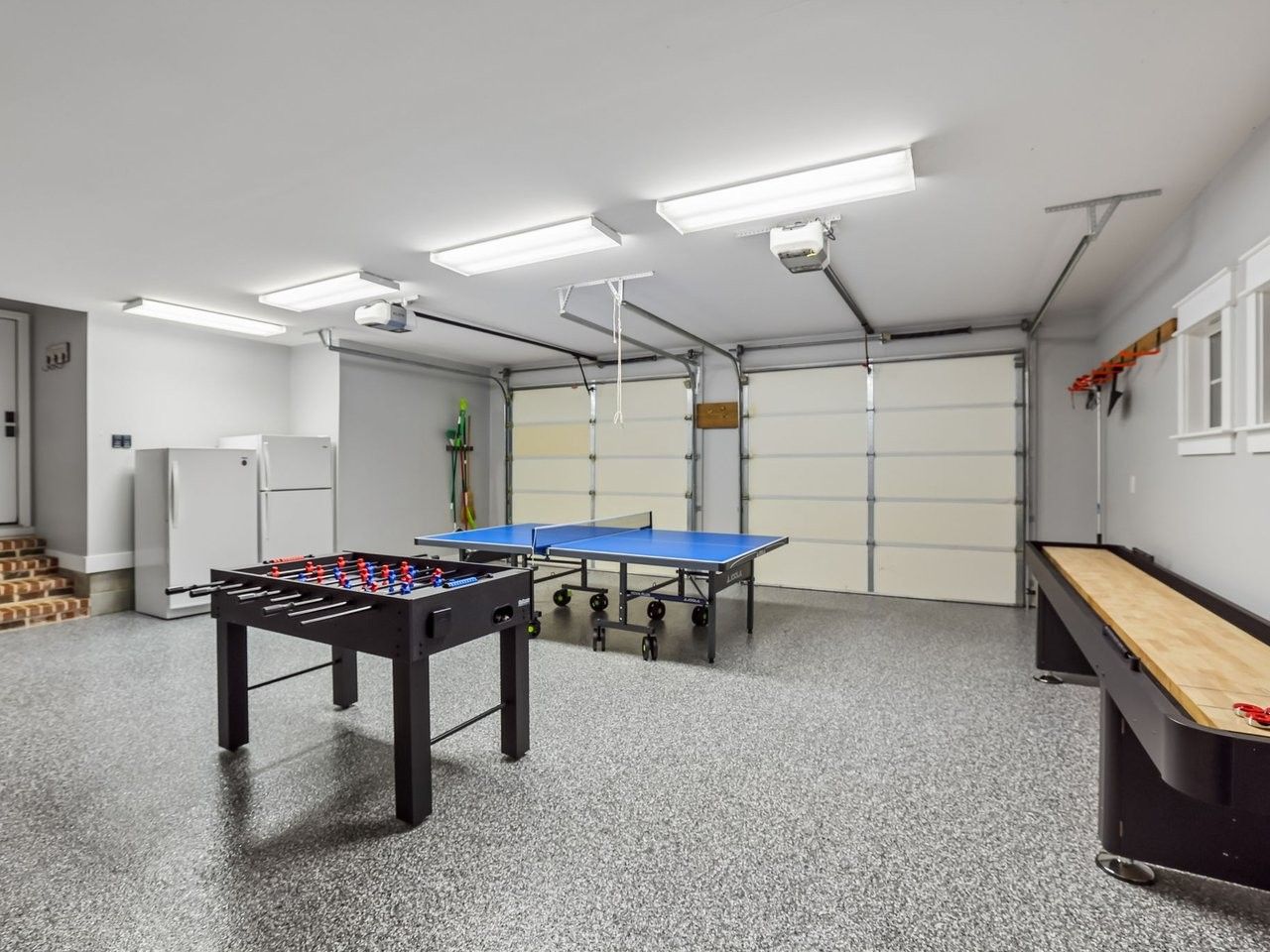 Ein Raum mit Tischfußballtisch, Pongtisch und einem blauen Tischfußballtisch.