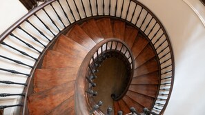 A spiral staircase with wooden steps and metal balusters. - Heritage Palace Hotel (Porto)