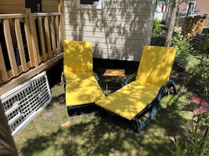 Eine Holzterrasse mit einem weißen Grill und einem kleinen Tisch.
