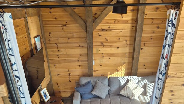 Une pièce chaleureuse avec un canapé gris, un fauteuil bleu et un plancher en bois.