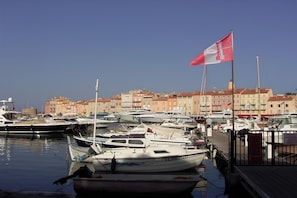 A marina with multiple boats docked, a clear sky, and buildings in the background. - Bright Apartment by the Ligurian sea (La croix-Valmer)