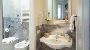 Een badkamer met een hygiëneslot, een wastafel en een spiegel.