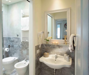 A bathroom with a bidet, a sink, and a mirror. - Vrbo Property (Firenze)
