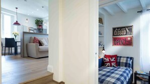 Een modern interieur met een trap die leidt naar een slaapkamer met een geruit sprei en een kussen met de Britse vlag.