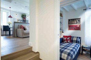 A modern interior with a staircase leading to a bedroom featuring a checkered bedspread and a British flag pillow. - Vrbo Property (Firenze)
