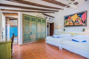 A room with a bed, a ceiling fan, a painting, and a door with a decorative design. - Charming Chalet for 8 in Pollensa (Pollensa / Pollença)