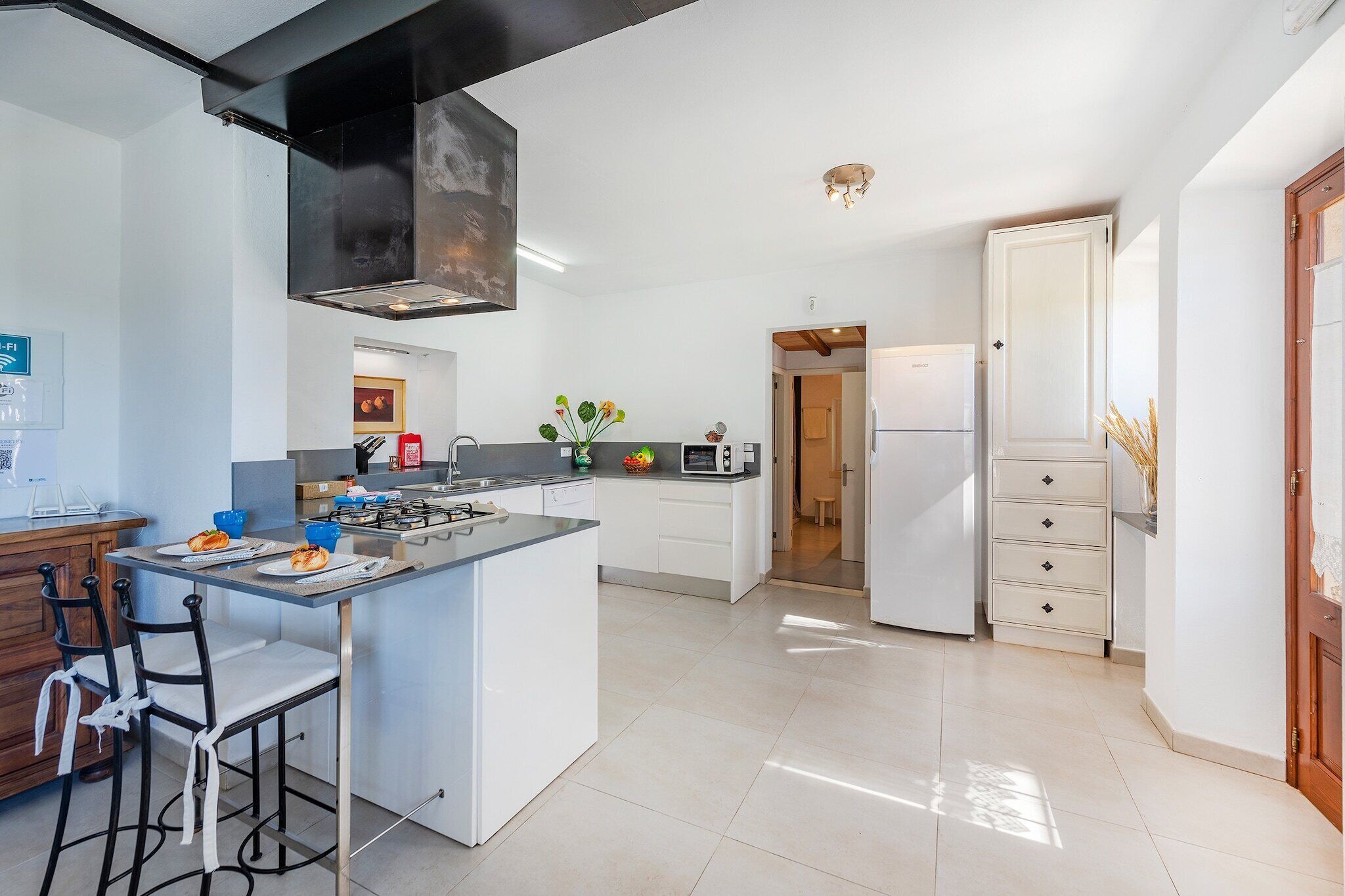 A modern kitchen with a central island, a stove, and a refrigerator.