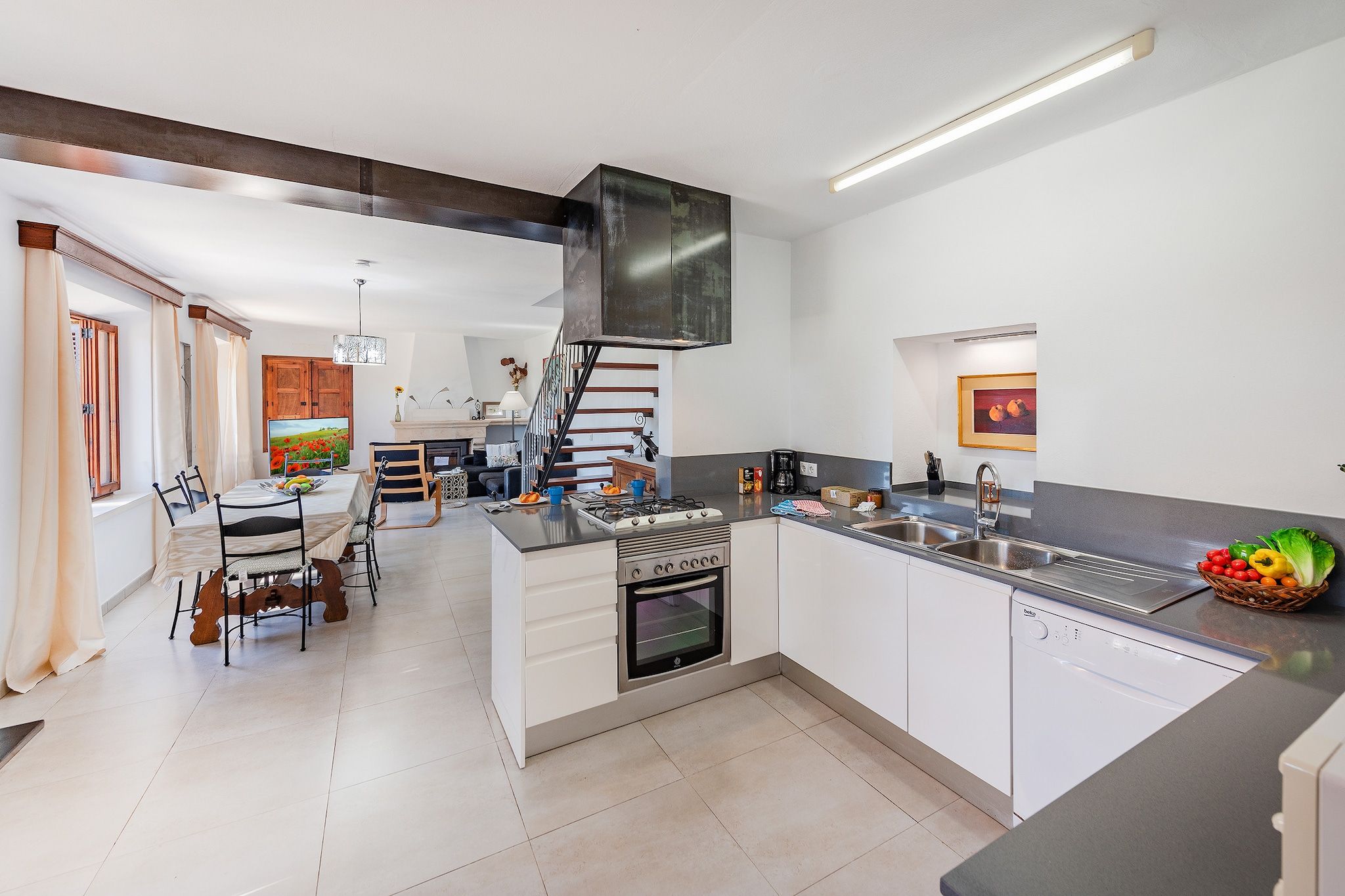 A modern kitchen with a built-in oven, a dishwasher, and a large island with a sink.