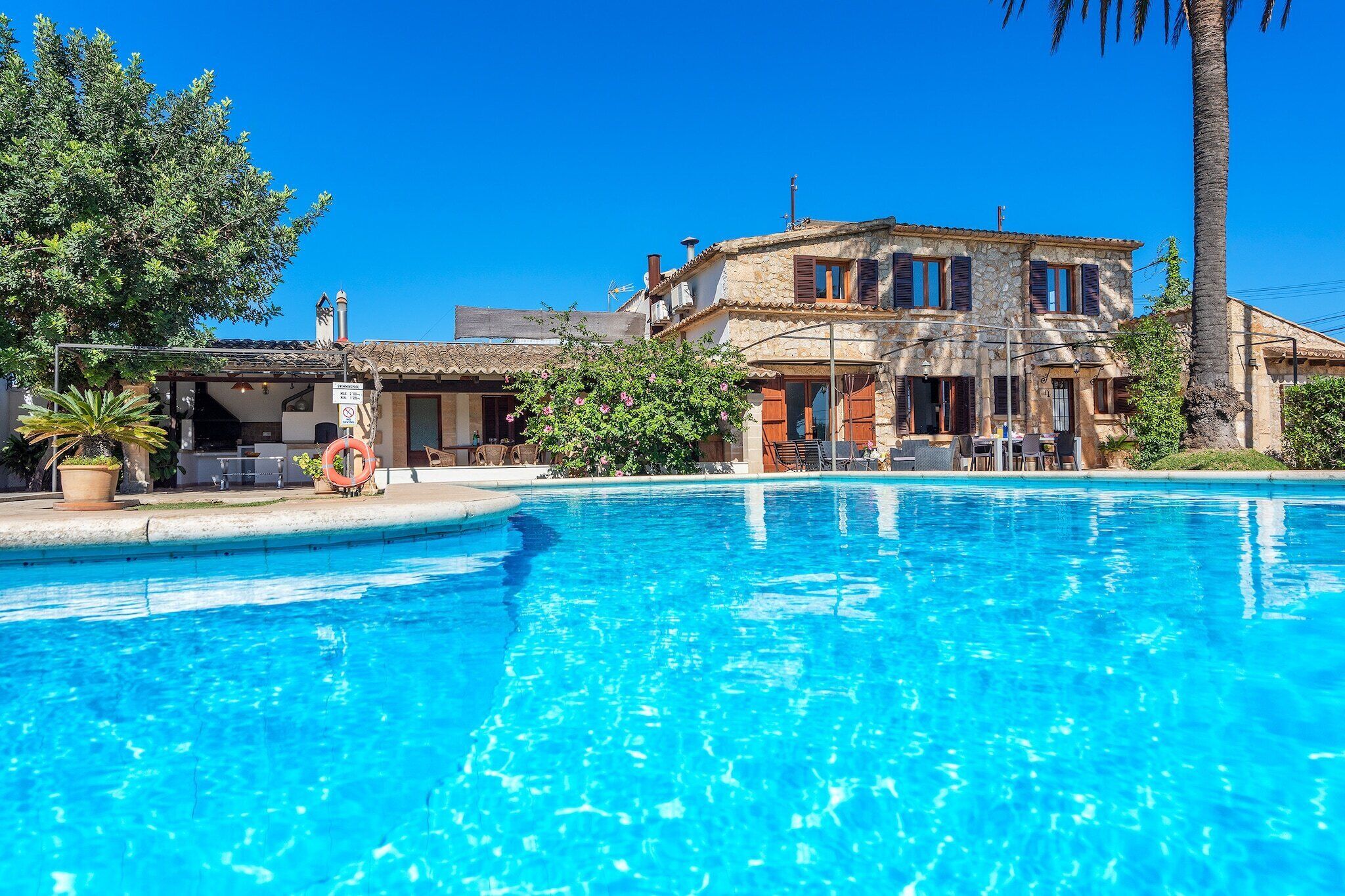 A clear blue pool with a stone building in the background.