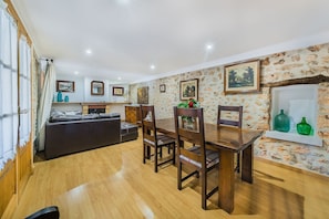 A dining area with a wooden table and chairs, a sofa, and a fireplace. - CASETA DE LLOSETA Ref VP22 1 (Lloseta)