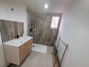 A modern bathroom with a white vanity, a shower with a glass door, and a small window. - Gîte M with Shared Pools, Wi-Fi & Air Conditioning in Codognan (Codognan)