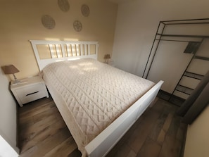 A bedroom with a bed, nightstands, a lamp, and a wardrobe. - Gîte M with Shared Pools, Wi-Fi & Air Conditioning in Codognan (Codognan)