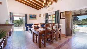 Uma sala de jantar com mobiliário de madeira, um candelabro e vista para o exterior.