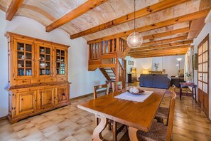 A spacious dining area with a wooden table, a built-in cabinet, and a staircase leading to an upper level. - Rustic Country Villa with Private Pool (Pollensa / Pollença)