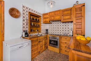 A kitchen with wooden cabinets, a built-in oven, and a coffee maker. - Rustic Country Villa with Private Pool (Pollensa / Pollença)