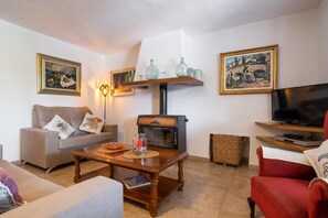 Ein Wohnzimmer mit einer Couch, einem Couchtisch, einem Fernseher und einem Kamin.