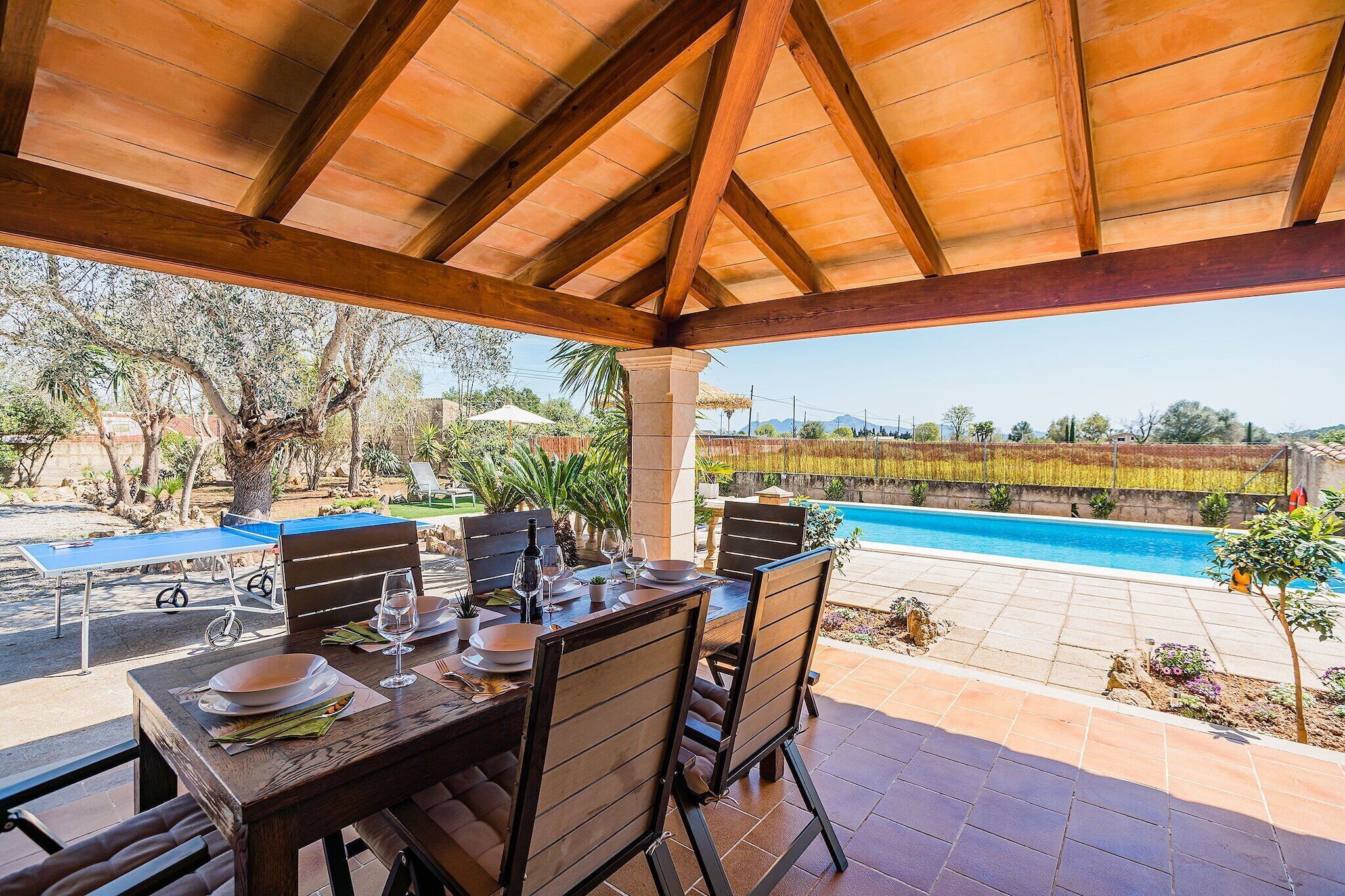 An outdoor dining area with a pool and a view of the vineyard.