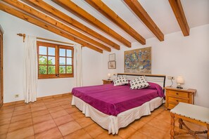 A bedroom with a bed, a nightstand, a bench, a window with curtains, and a painting on the wall. - Secluded Country Villa with Pool (Pollensa / Pollença)