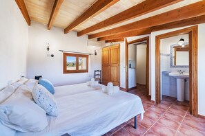 A bedroom with a bed, a window, a wardrobe, and a bathroom with a sink. - Country Villa with Garden for 6 (Pollensa / Pollença)