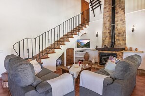 A living room with a staircase, a fireplace, and two grey sofas. - Country Villa with Garden for 6 (Pollensa / Pollença)