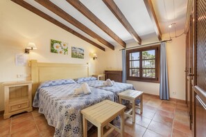 A bedroom with a large bed, two bedside tables, a wooden headboard, a window with curtains, and a wall-mounted lamp. - Grand Majorcan Retreat with Pool (Pollensa / Pollença)