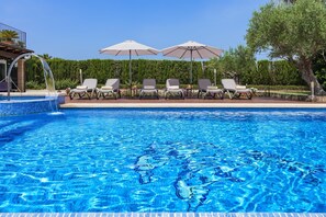 A swimming pool with clear blue water, surrounded by lounge chairs and umbrellas. - Grand Majorcan Retreat with Pool (Pollensa / Pollença)