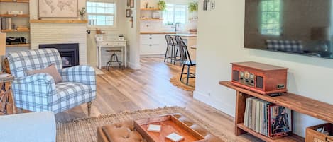A living room with a fireplace, a television, and a bookshelf.
