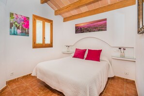 A bedroom with a bed, two pillows, a window, and two wall-mounted shelves. - Rustic Country Retreat for 4 (Pollensa / Pollença)