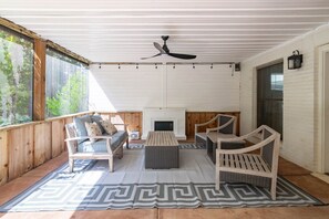 Un espace extérieur abrité, doté d’un ventilateur de plafond, d’une cheminée et offrant une vue sur le paysage.