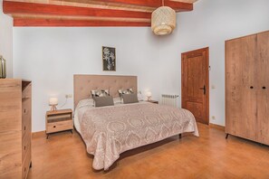 A bedroom with a bed, bedside tables, a wardrobe, a radiator, and a hanging light fixture. - Single-Level Villa with Pool, Pollença (Pollensa / Pollença)