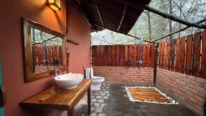 Une salle de bain avec un banc en bois, un grand miroir, un lavabo et des toilettes.