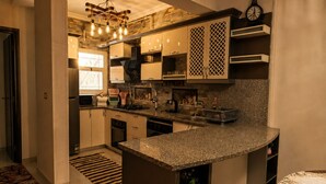 Una cocina moderna con encimeras de granito, electrodomésticos de acero inoxidable y horno empotrado.