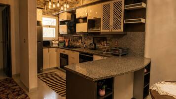 A modern kitchen with granite countertops, stainless steel appliances, and a built-in oven.