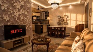 A modern living room with a television, sofa, coffee table, and decorative wall.