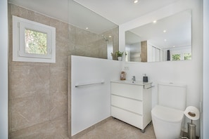 A modern bathroom with a glass shower enclosure, a white vanity with a mirror, and a toilet. - Premium Pollensa Country Villa for 6 (Pollensa)