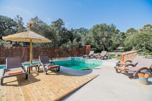 A pool area with lounge chairs and a thatched umbrella. - Premium Pollensa Country Villa for 6 (Pollensa)