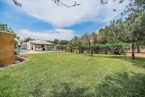A backyard with a swimming pool, a covered patio, and a grassy lawn. - Romantic Pollensa Country Escape (Pollensa / Pollença)