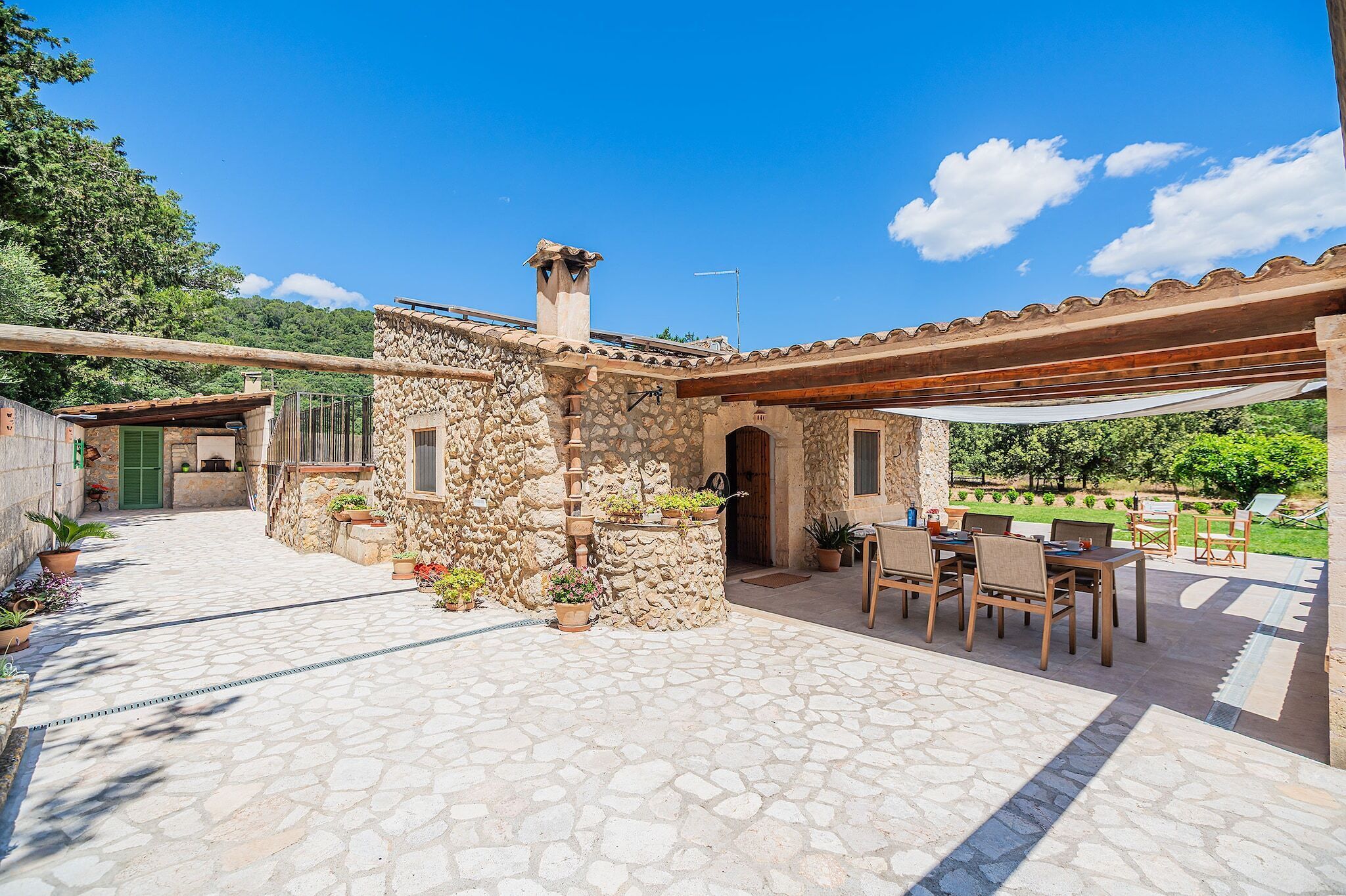 A stone building with a patio area, outdoor seating, and potted plants.