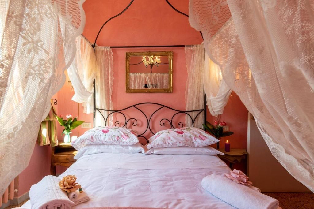 A bed with a canopy, a bedside table with a lamp, and a mirror on the wall.