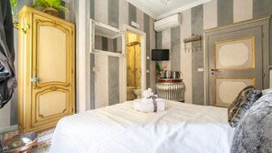 Ein Hotelzimmer mit einem großen Bett, einem Kleiderschrank, einem Spiegel, einem Fernseher und einer Tür.