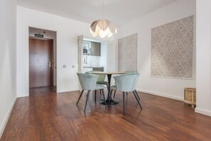 Ein Essbereich mit Holzboden, einem Tisch und vier Stühlen sowie einer Pendelleuchte.