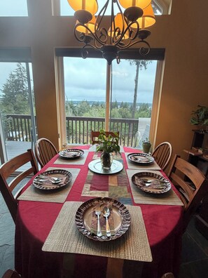 Une table à manger dressée pour six personnes, avec vue sur l’extérieur.
