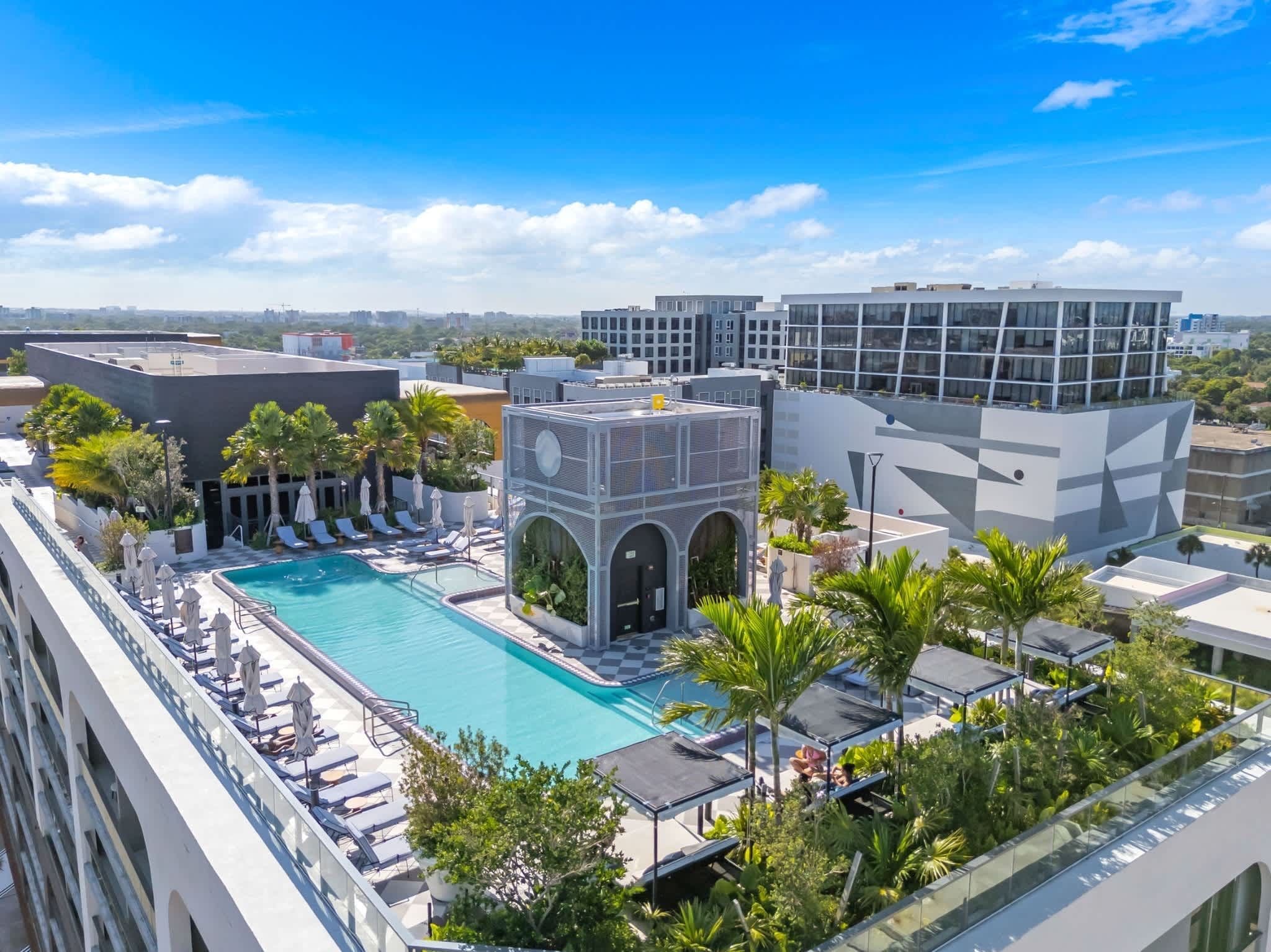 A rooftop pool with lounge chairs and a view of the cityscape.