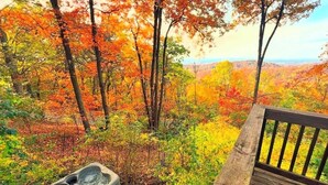 A hot tub on a wooden deck with a view of a forest in autumn colors. - Epic Mountaintop Views • HotTub • Billiard Near Shenandoah Natl Park • Vineyards (Front Royal)