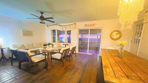 A living room with a sofa, chairs, a wooden table, a ceiling fan, and a sliding glass door leading to an outdoor area. - Epic Mountaintop Views • HotTub • Billiard Near Shenandoah Natl Park • Vineyards (Front Royal)