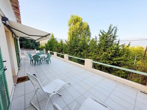 Un balcon aménagé avec du mobilier d’extérieur, une table et des chaises.