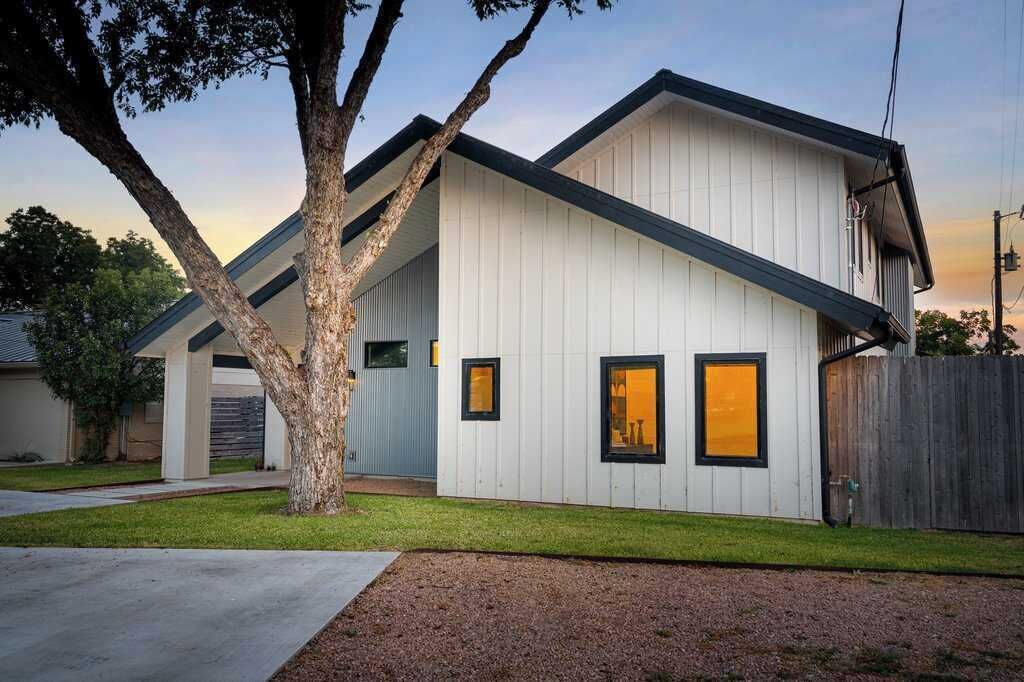 Une maison moderne de plain-pied, dotée d’un toit en pente, d’un garage apparent et d’une pelouse bien entretenue.