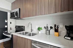 Een moderne keuken met roestvrijstalen apparatuur, een dubbele spoelbak en houten kastjes.