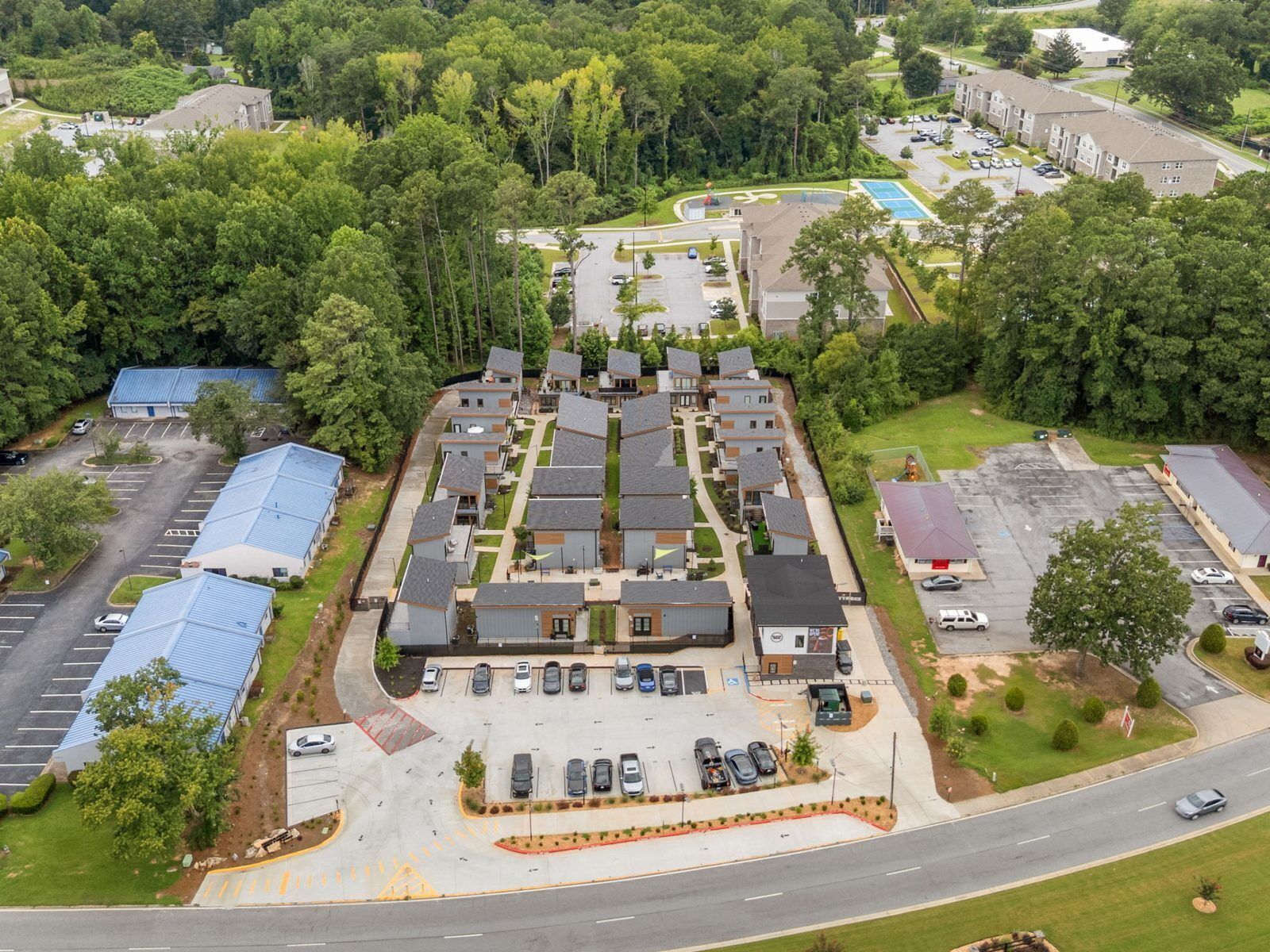 A residential area with multiple apartment buildings, a parking lot, and a road.