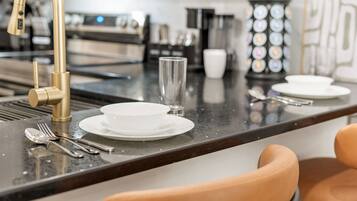 A modern kitchen with a central island, stainless steel appliances, and a gold faucet.
